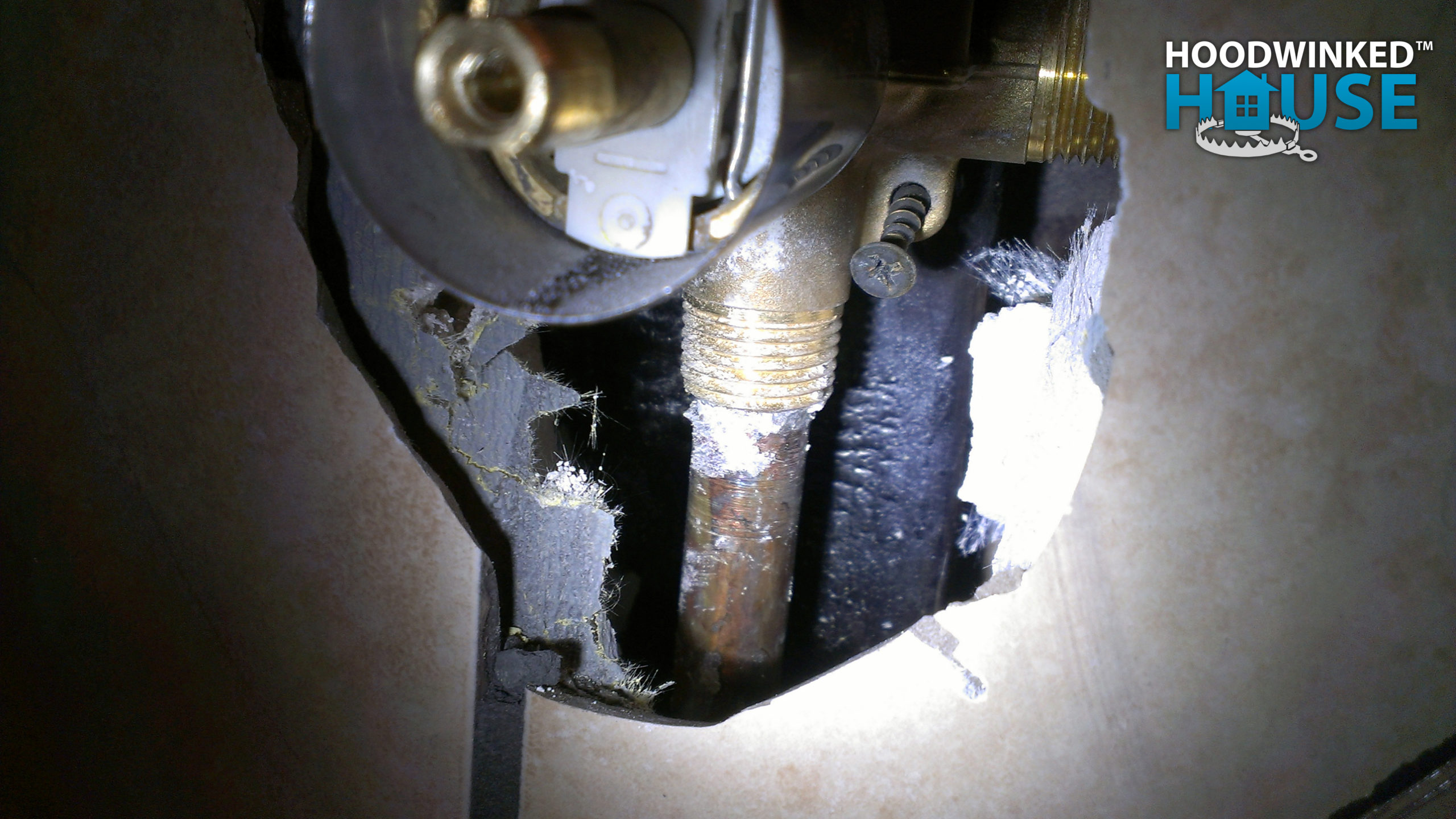 Badly burnt framing behind shower control manifold. 