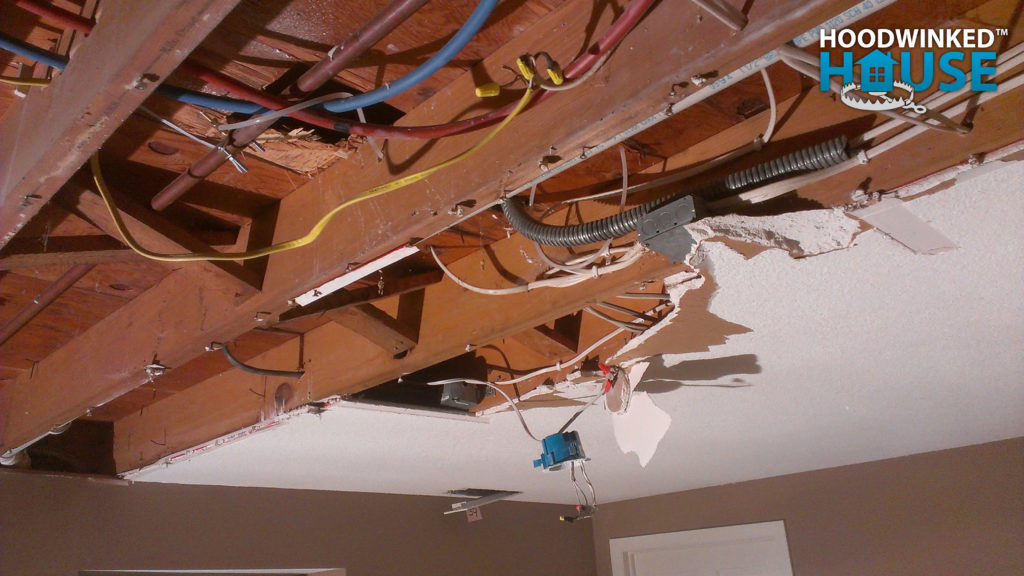 Partially demolished ceiling with drywall covering junction boxes