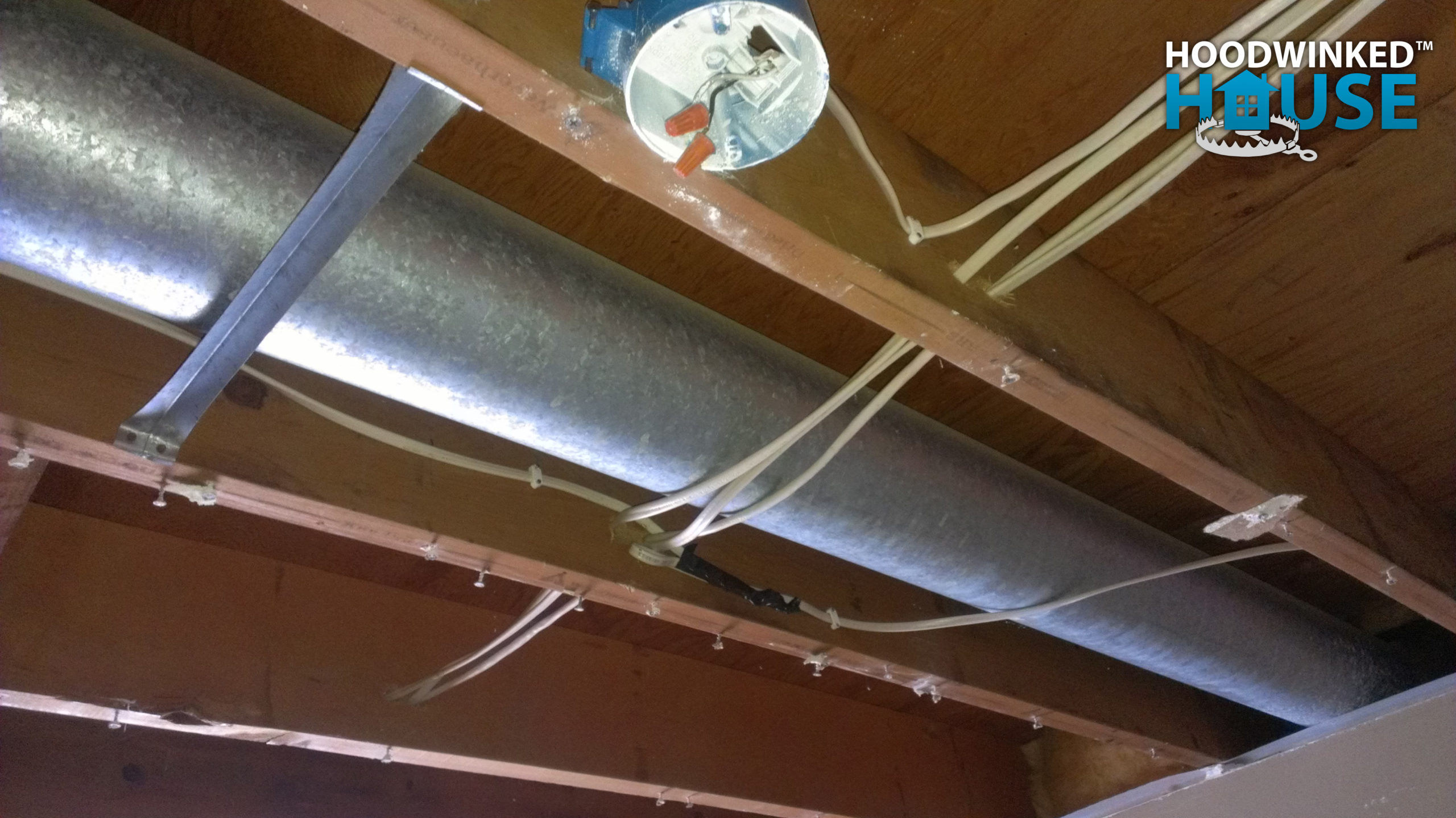 A demolished ceiling reveals a wire splice without a junction box that was illegally hidden behind the drywall.