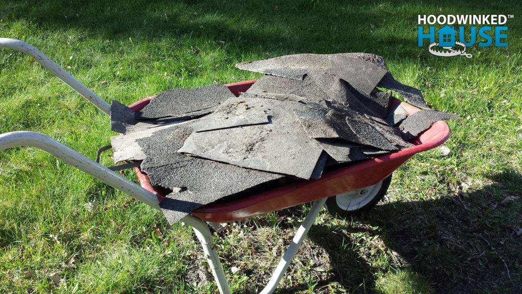 Roofing shingles found in an overgrown lawn after a roofing job done without a permit.