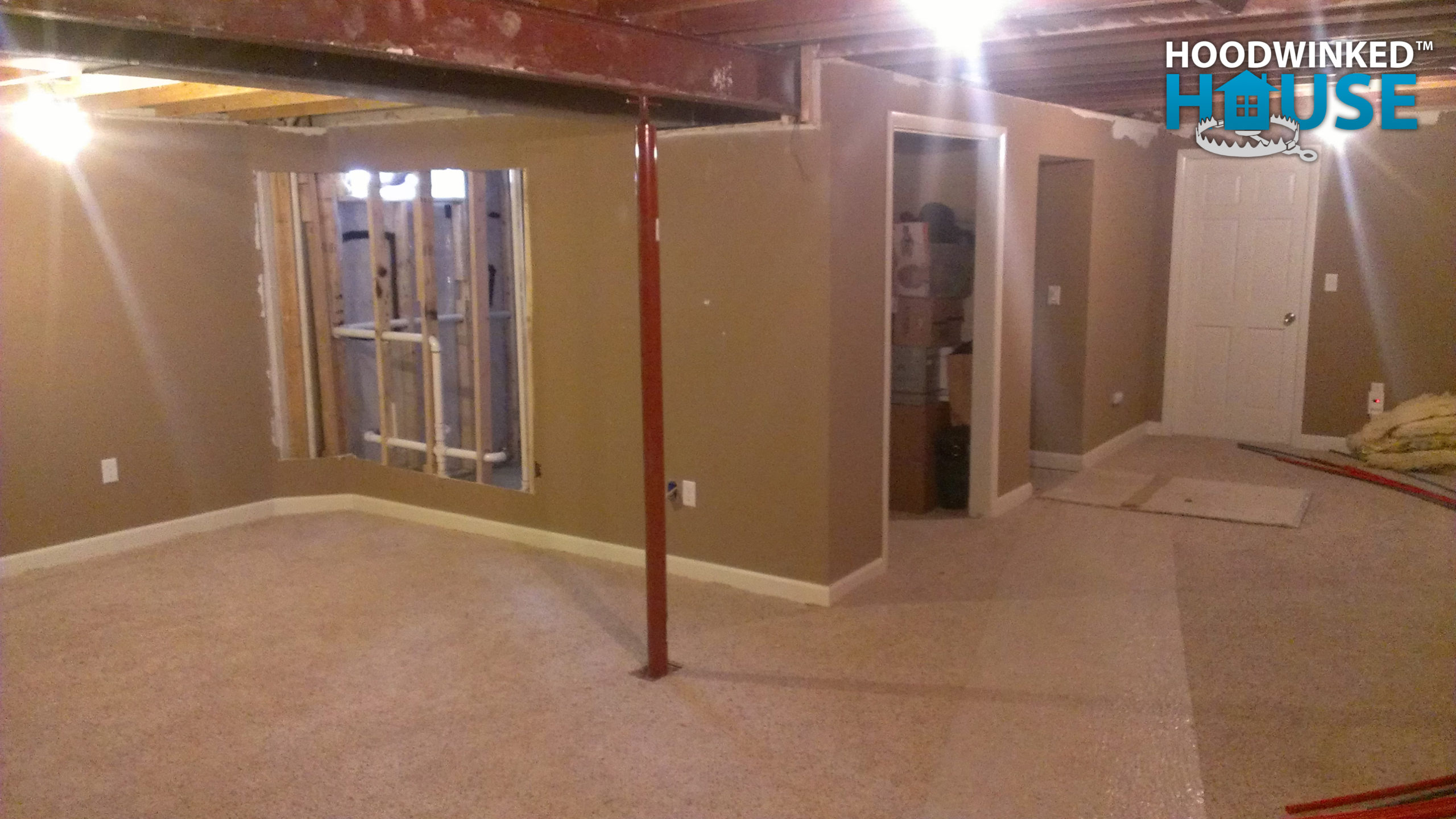 A new metal column has been installed in a basement to support an I-beam in the ceiling. \