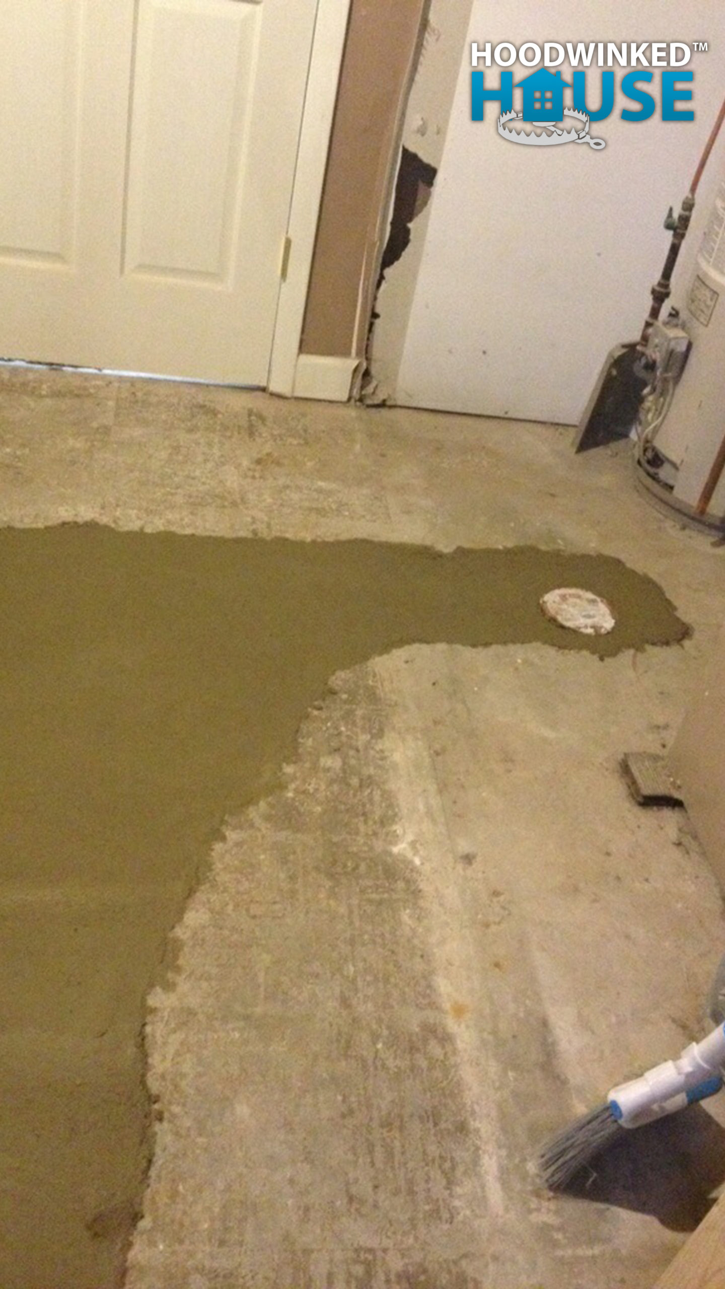 New concrete cures around a newly installed basement floor drain.