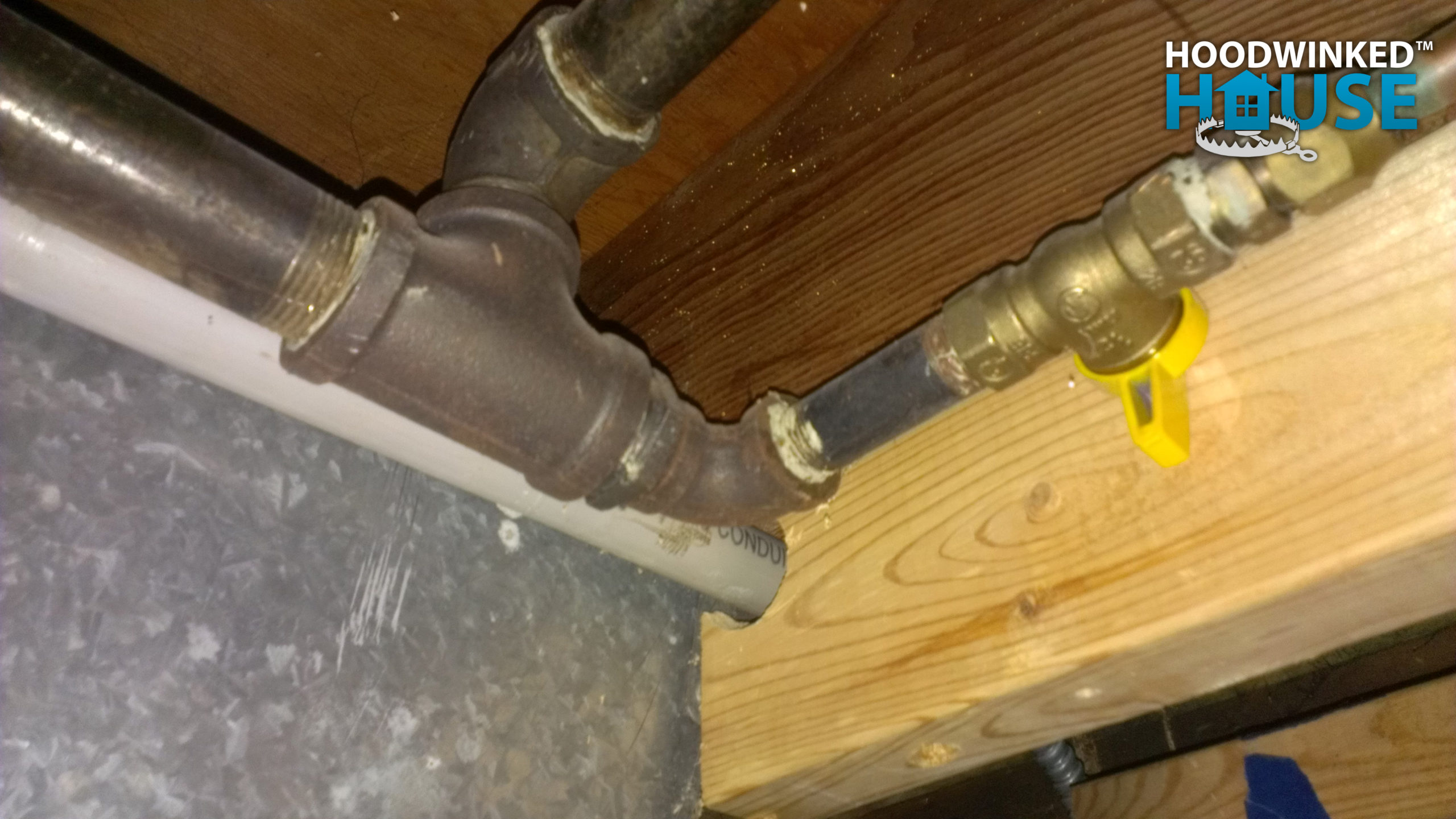 A gas shutoff valve in a basement ceiling.