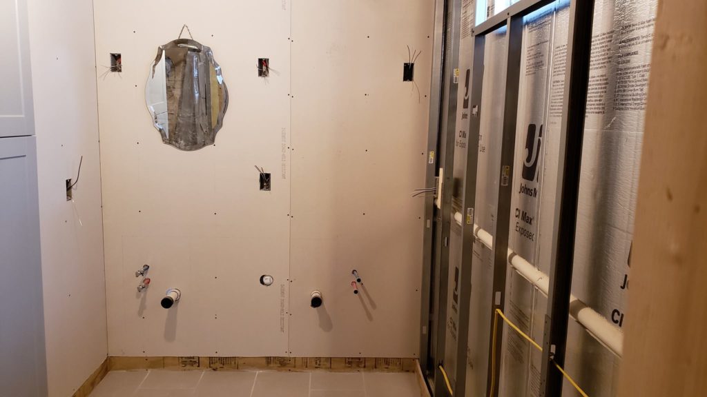 Electrical rough-in of a basement bathroom showing several junction boxes in drywall.