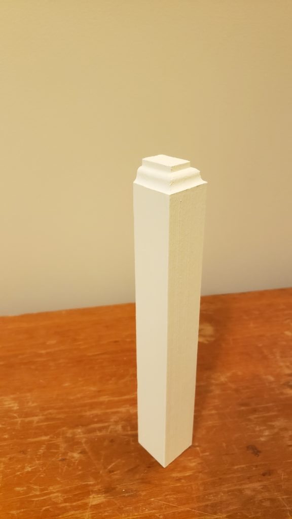 A custom made plinth block, painted white, for tall baseboards.