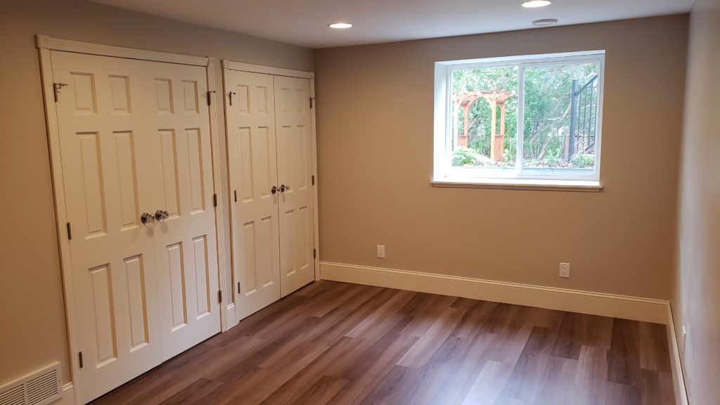 Two closets in a garden-level basement bedroom with an egress window.