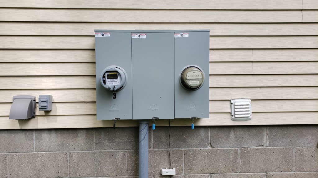 Duplex electrical meters on the outside of a house.