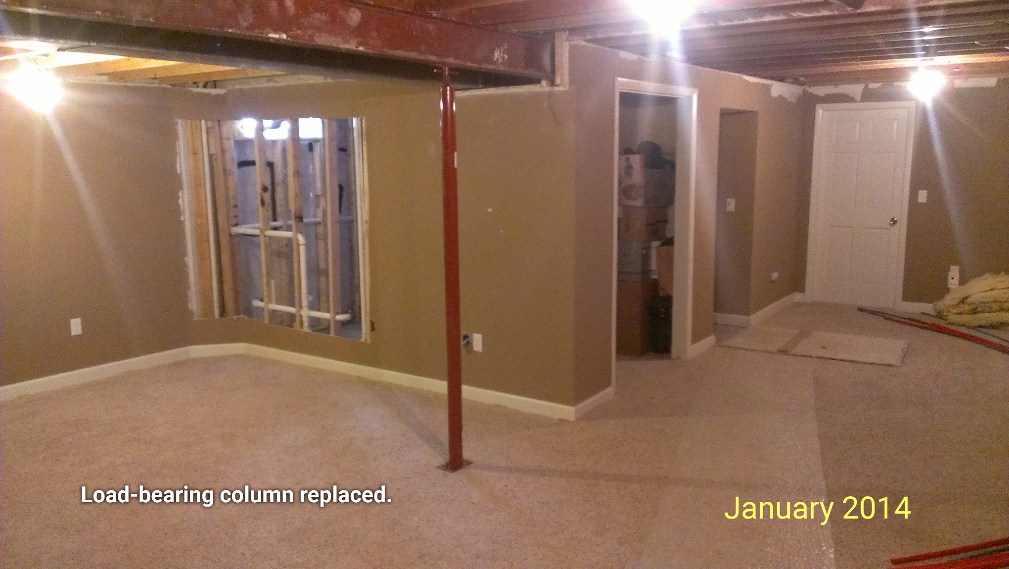 A finished basement as seen in January 2014 with a load bearing column replaced under a central beam.