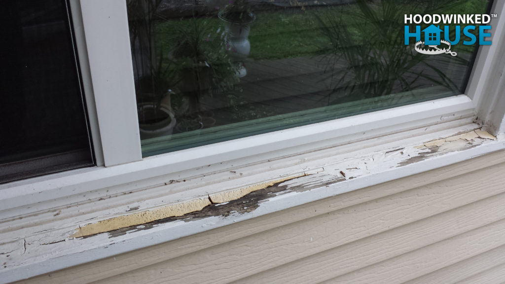 Rotten window sill that has been filled with expanding foam and concealed with paint