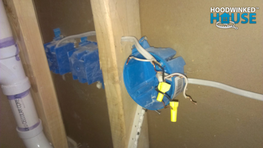 Ceiling junction box used in a wall and covered with drywall.