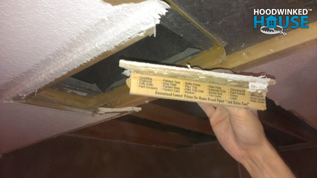 Paint stir sticks were used to reduce the size of a hole cut in the central heat duct, and then illegally mount a heat register to it.