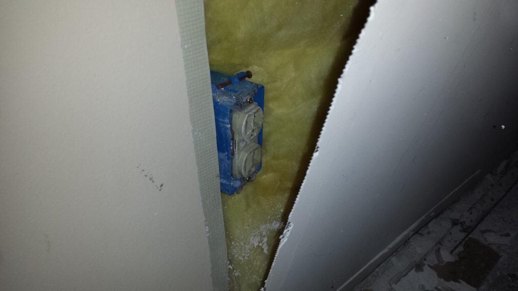 An outlet covered with drywall is discovered during demolition.