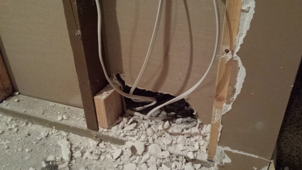 Basement demolition reveals a hole kicked into drywall for wiring.
