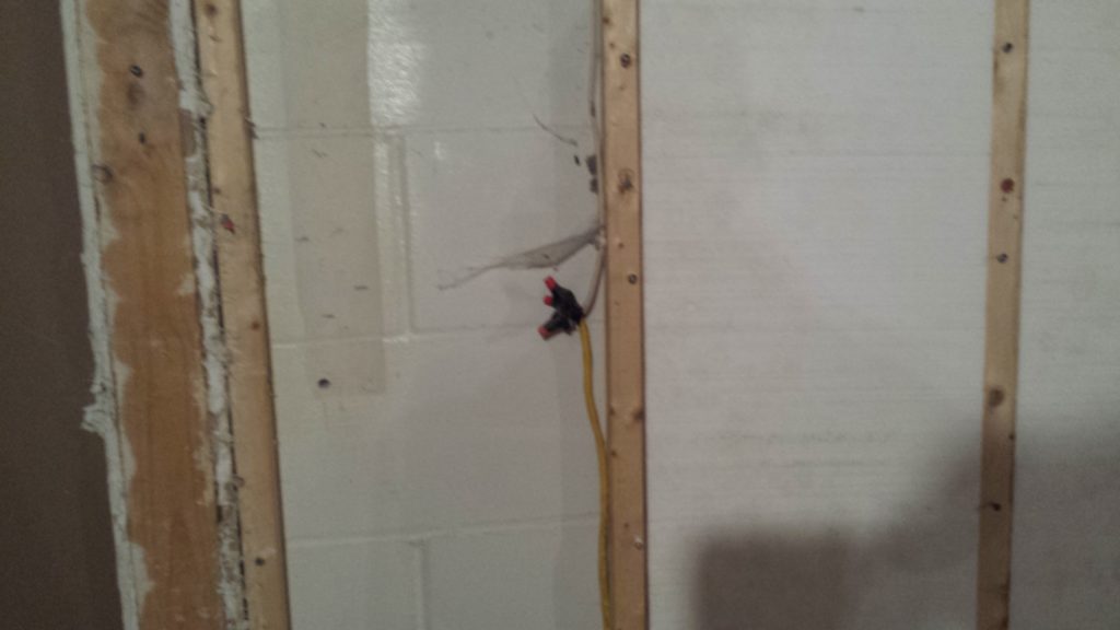 Basement demolition reveals a wire splice without a junction box that was hidden behind drywall.