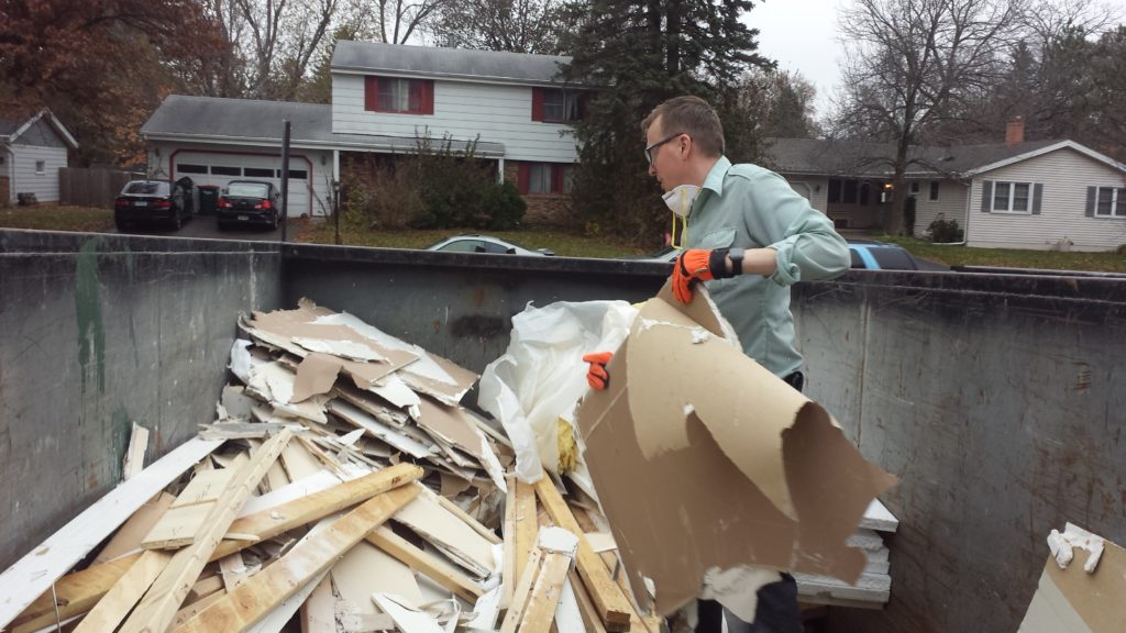 Demolition debris is loaded into a dumpster.