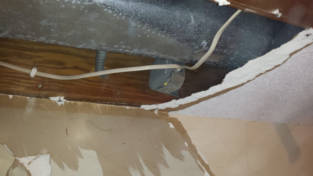 Demolition reveals a ceiling junction box that was hidden behind drywall.