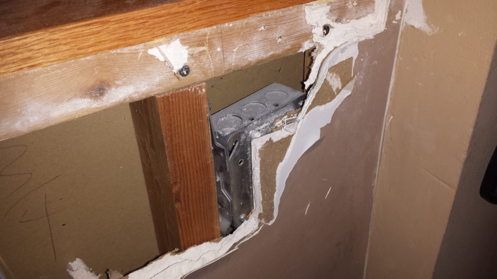 Junction box illegally covered with drywall.