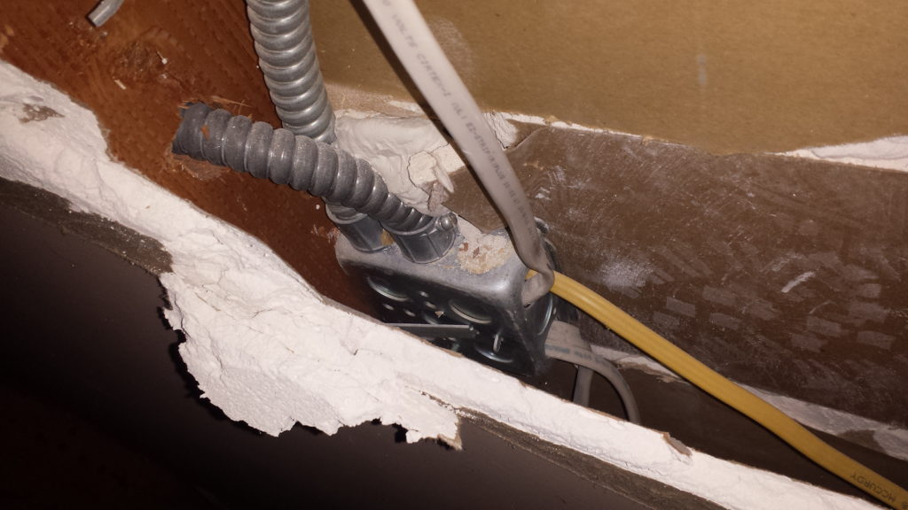 Junction box illegally covered with drywall.