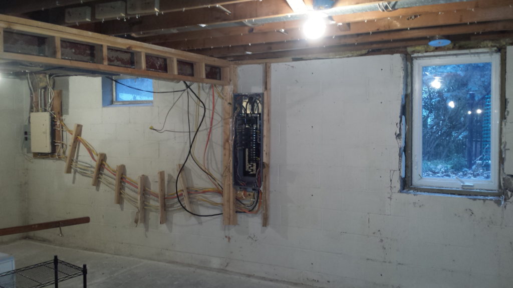 Basement electrical service panel with framing demolished.