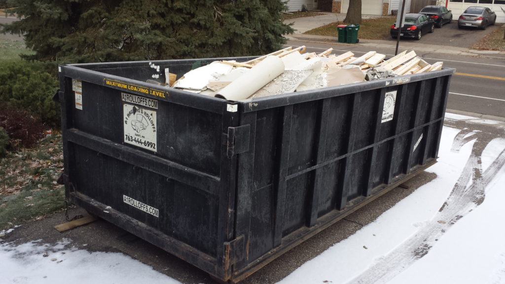 A yard dumpster full of demolition debris.