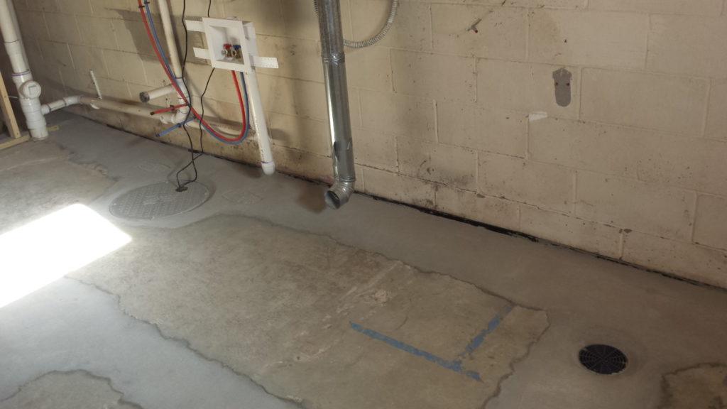 New drain tile and floor drain in a basement.