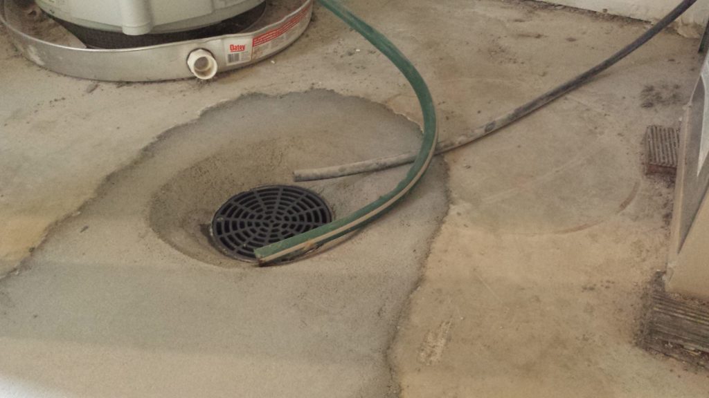 Concrete swale around a new floor drain in a basement.