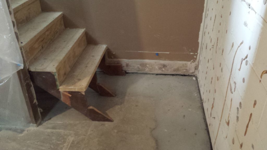 Basement stairs with landing removed for drain tile installation.