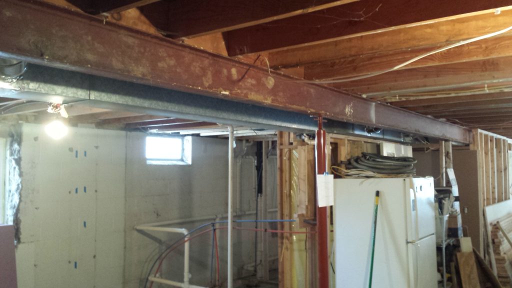 A steel I-beam in a basement that needs soffit framing.