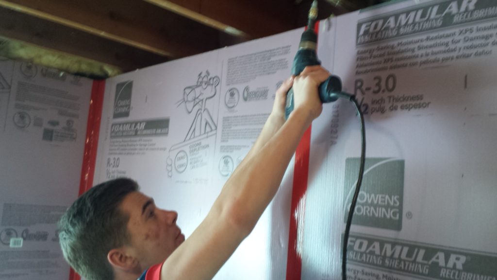 Pascal removes old drywall screws from the joists.