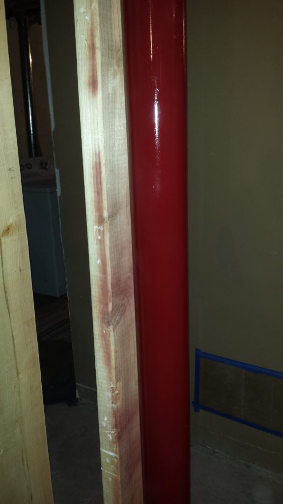 A repainted support column in a basement.