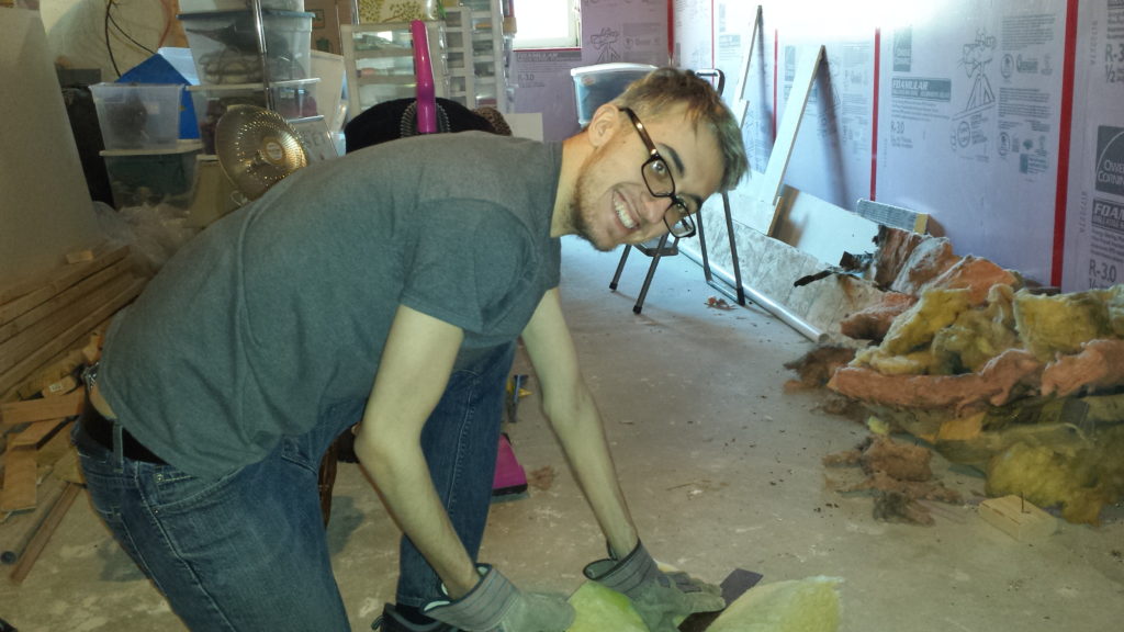 Harry measures and cuts some insulation for the basement.