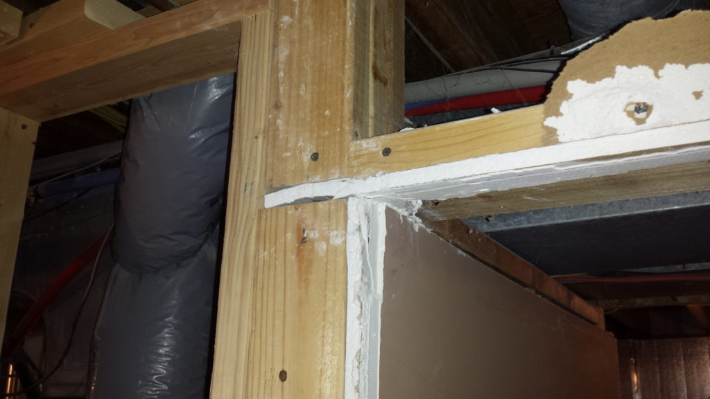 A house flipper did sloppy carpentry by framing over existing drywall.