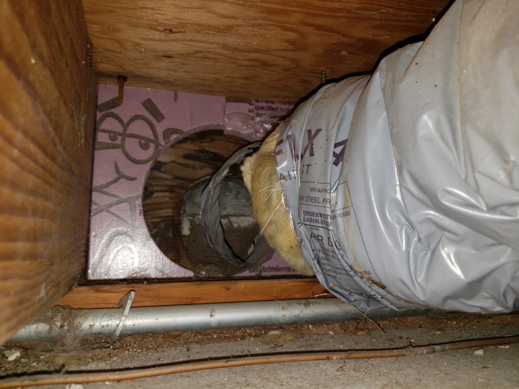 A flexible fresh air intake where it meets the rim joist of a house.