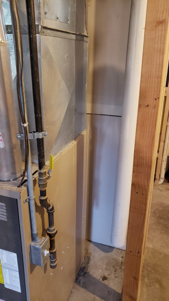 A PVC pipe used as a fresh air intake for a furnace.