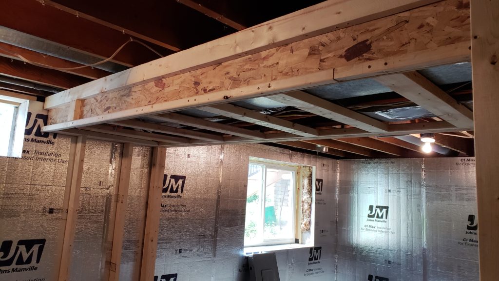 Soffit built around main air ducts in a basement ceiling.