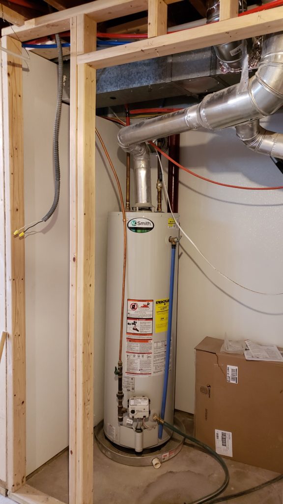 A water heater in a closet lined with washdown paneling.