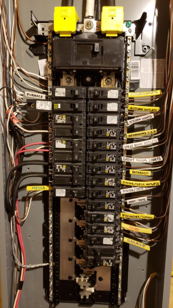 Electrical service panel with the cover off showing neatly organized and labeled breakers.