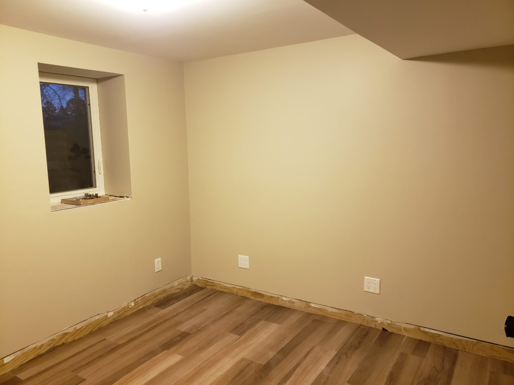 Finished basement bedroom wall with an egress window.