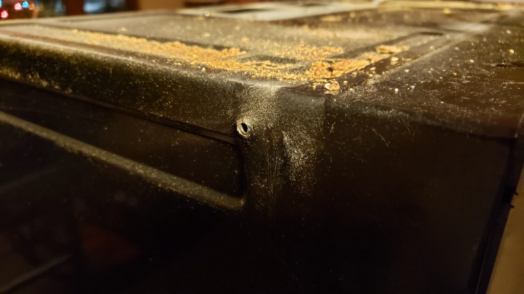 Side of a microwave that has a hole from a screw.