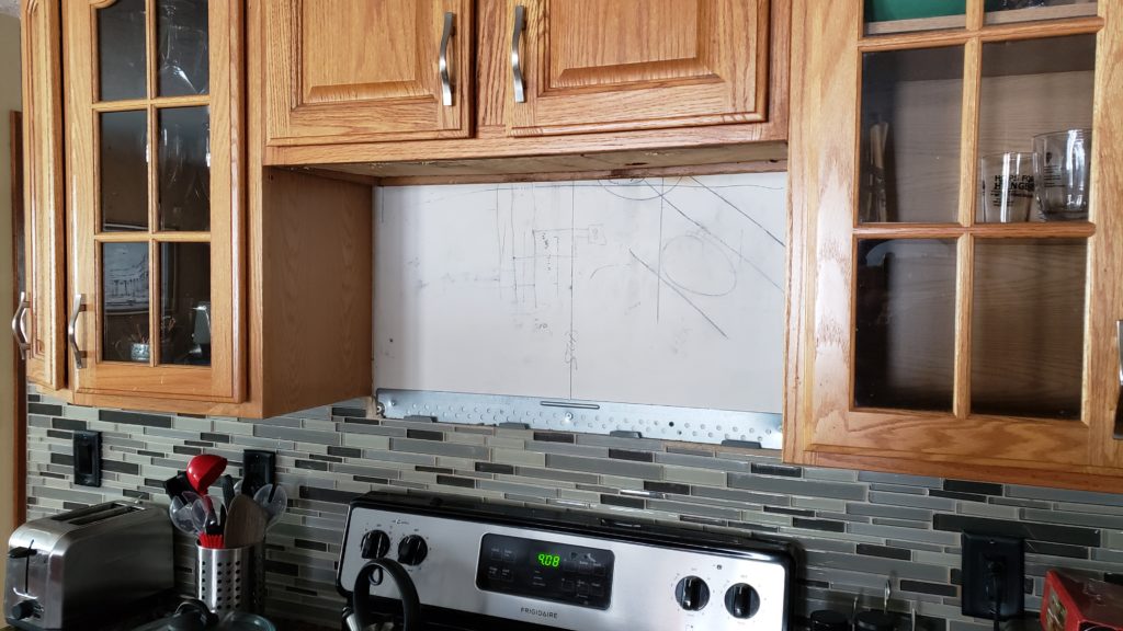 Space where an over-the-range microwave would be installed below some kitchen wall cabinets.