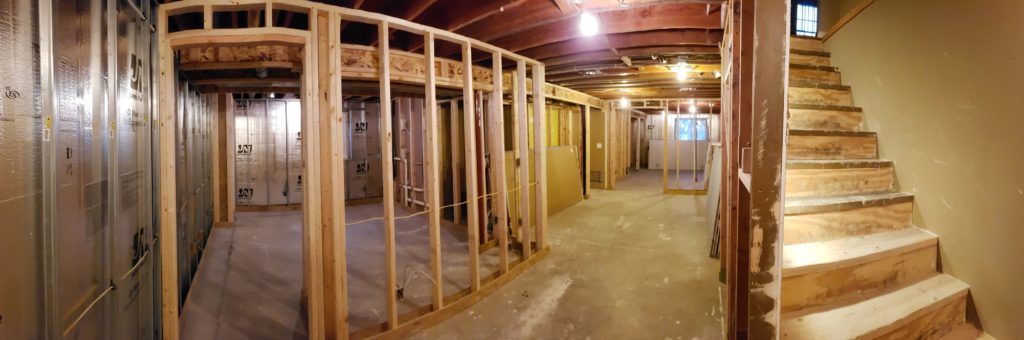 Panoramic view of stud walls in an unfinished basement.